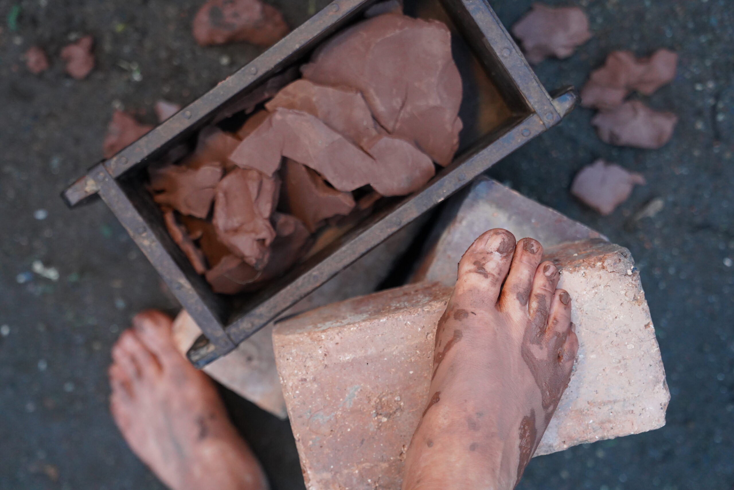 A pair of feet covered in clay.
