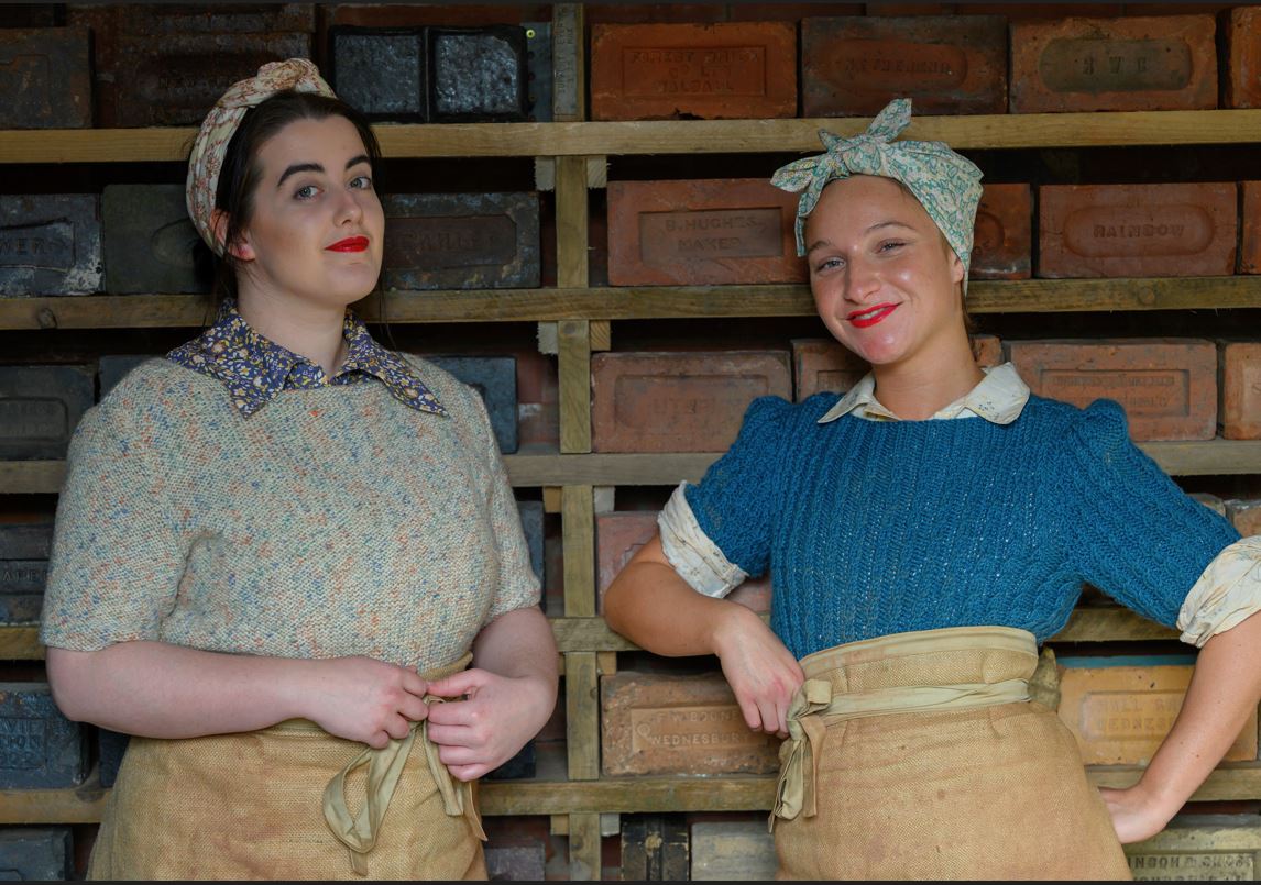Brickmakers posing with a wall full of bricks