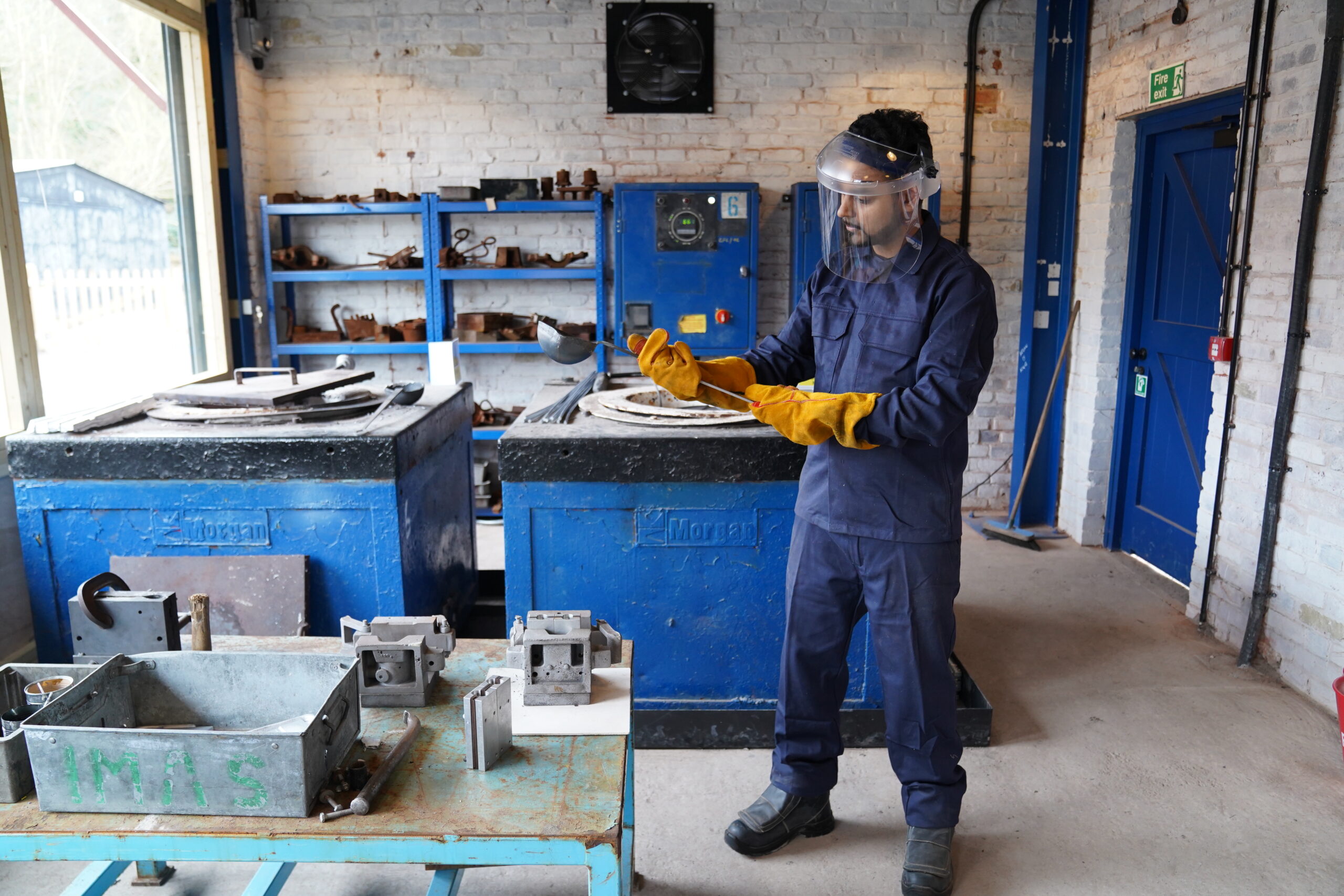 A costumed character dressed in overalls demonstrates in J. H. Lavender Aluminium Factory.